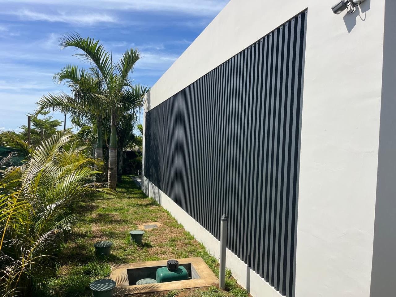 The west facade of the villa with its timber screen, inside the Mont Choisy golf estate