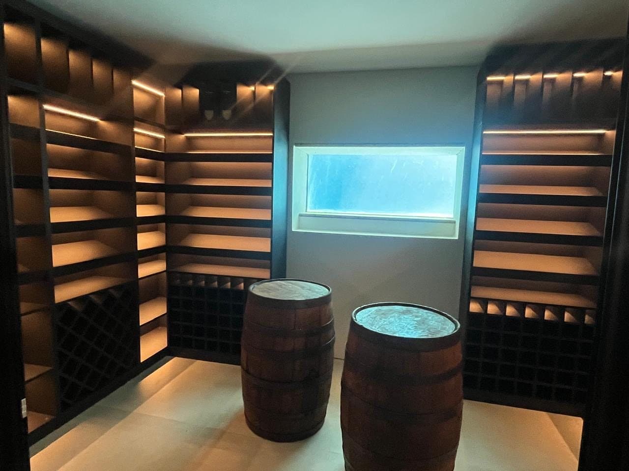 Wine cellar with lit racks and two oak barrels
