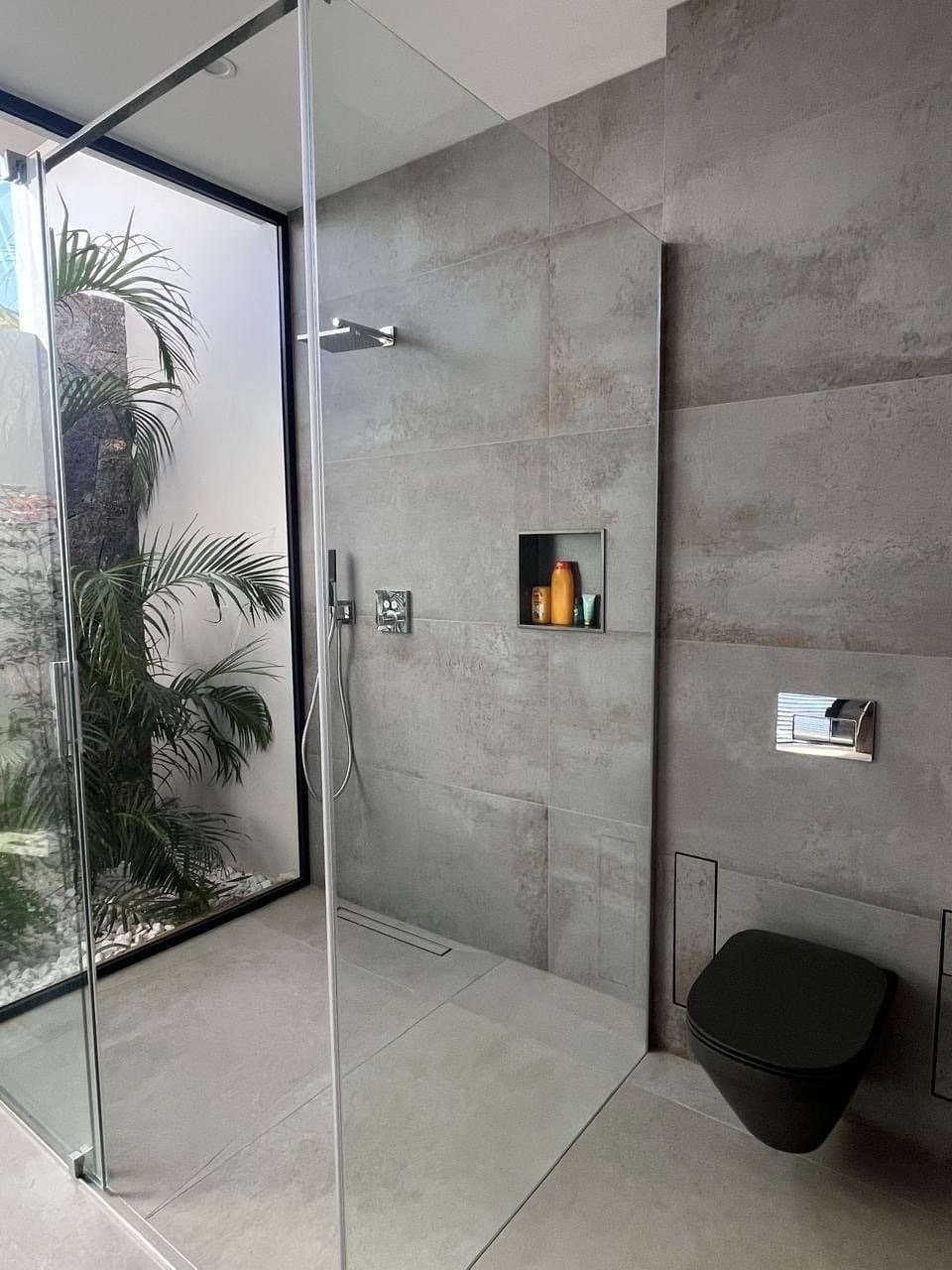 Walk-in shower and black wall-hung toilet