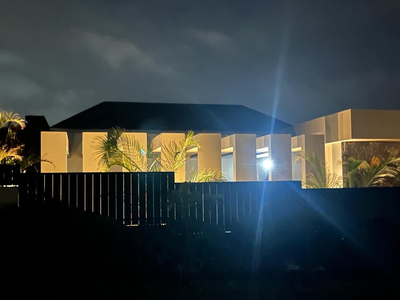 The street facade of the villa at night