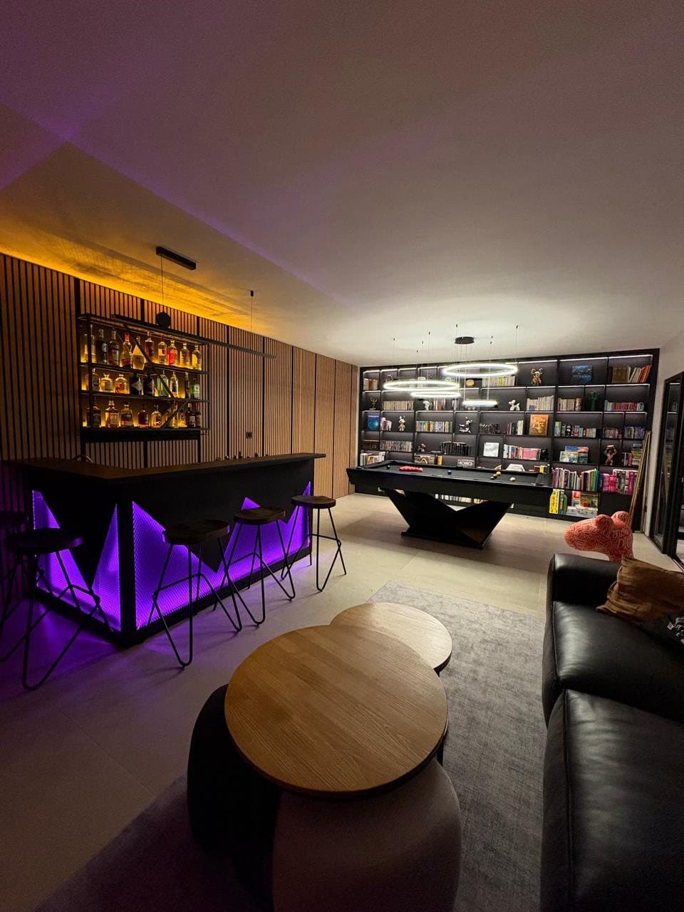 Games room with backlit purple bar, library wall and billiard table