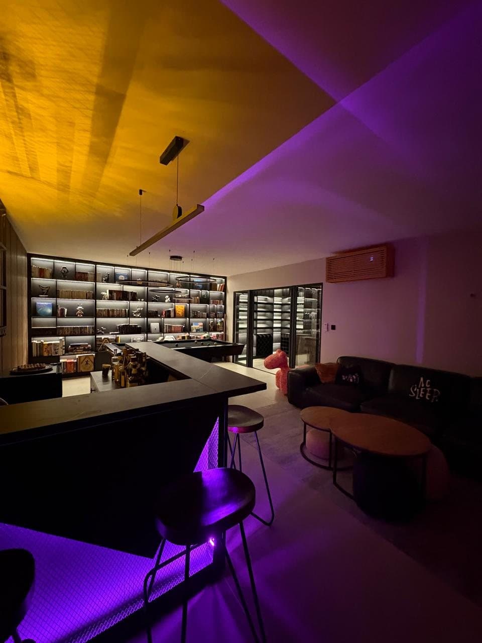Black leather sofa and round oak tables in the games room