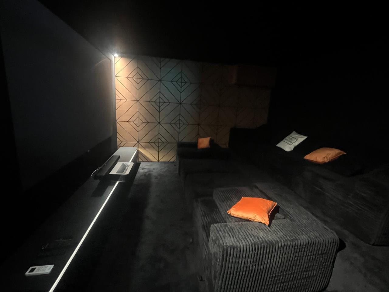 Home cinema with two rows of grey corduroy sofas