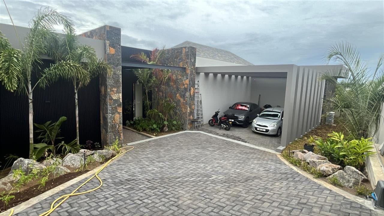 The entrance of the villa with the carport and the driveway